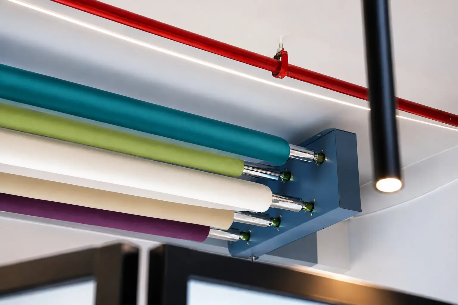 Colorful seamless paper backdrop rolls mounted on ceiling rail at ONQOL photography and content studio in Amman